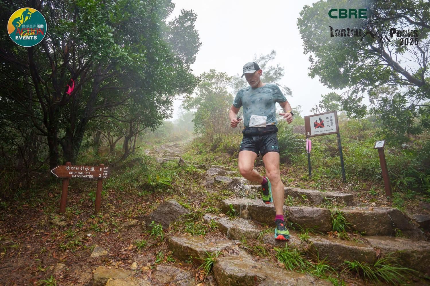 Rich Cowler climbing rocky steps in dense mist at CBRE Lantau 2 Peaks